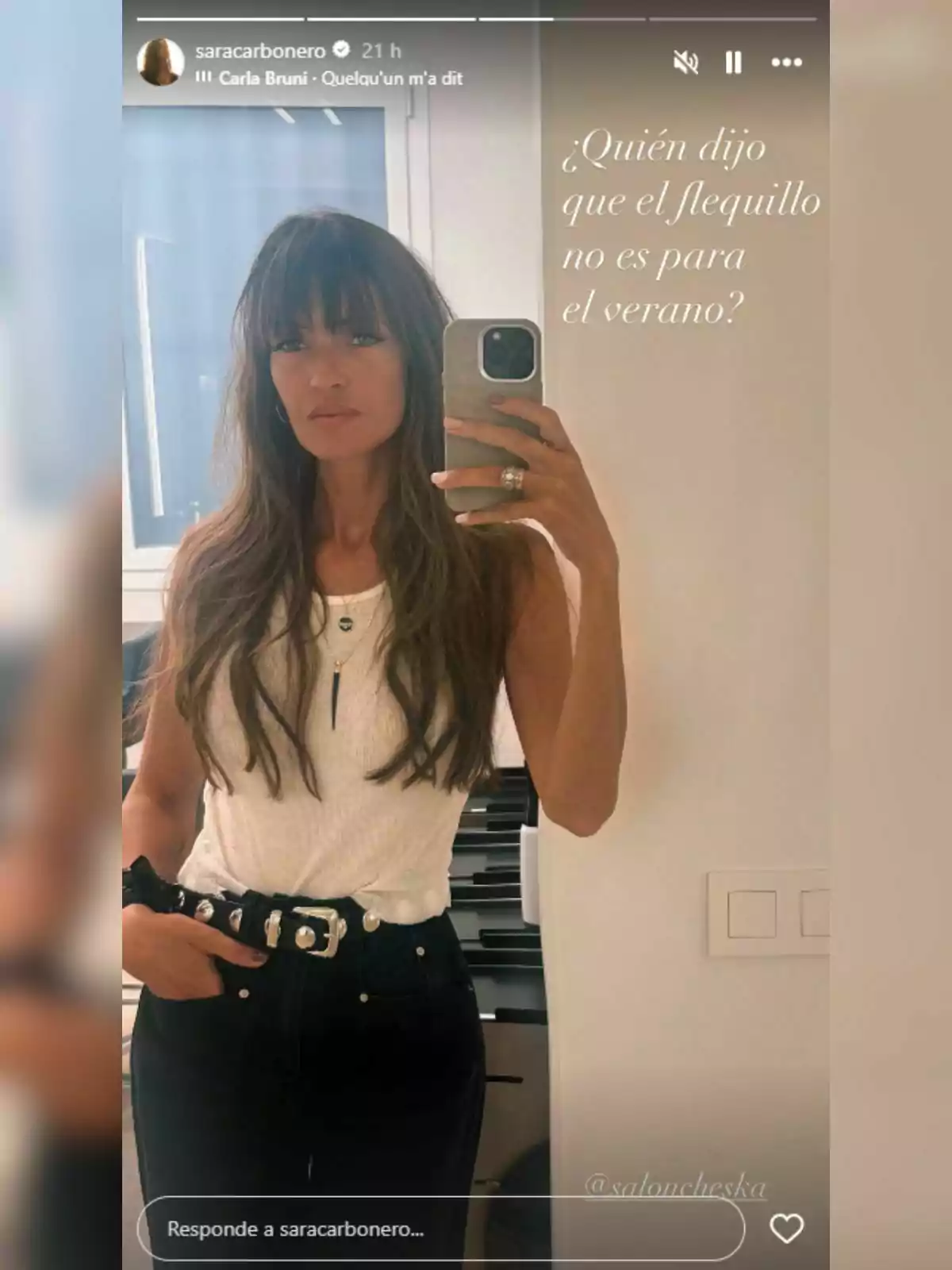Sara Carbonero con flequillo y cabello largo se toma una selfie frente al espejo usando un top blanco y pantalón oscuro, con la frase en la imagen que cuestiona si el flequillo es solo para el verano. Sara Carbonero con flequillo y cabello largo se toma una selfie frente al espejo usando un top blanco y pantalón oscuro, con la frase en la imagen que cuestiona si el flequillo es solo para el verano.