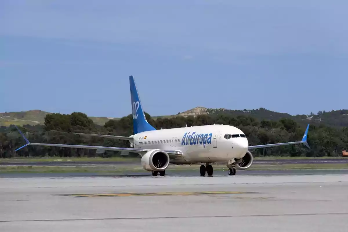 Avión de Air Europa rodando por la pista de un aeropuerto con árboles y colinas al fondo