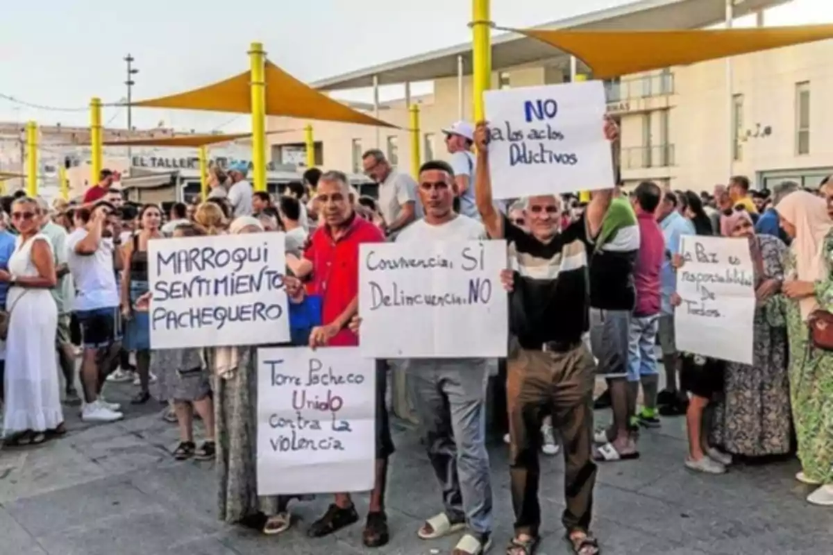 Varias personas participan en una manifestación pacífica en la calle sosteniendo carteles con mensajes en contra de la violencia y la delincuencia, promoviendo la convivencia y la responsabilidad colectiva.