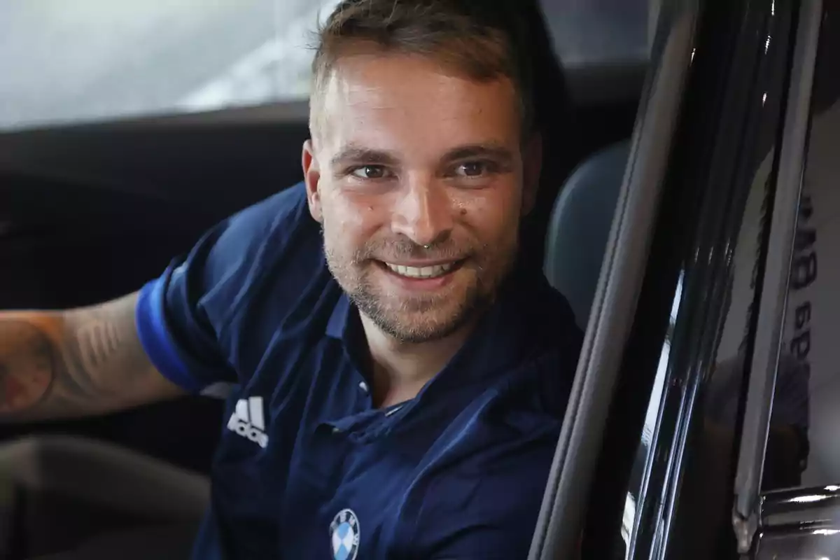 José María Almoguera sonriente con barba corta y camiseta azul de BMW sentado dentro de un automóvil José María Almoguera sonriente con barba corta y camiseta azul de BMW sentado dentro de un automóvil