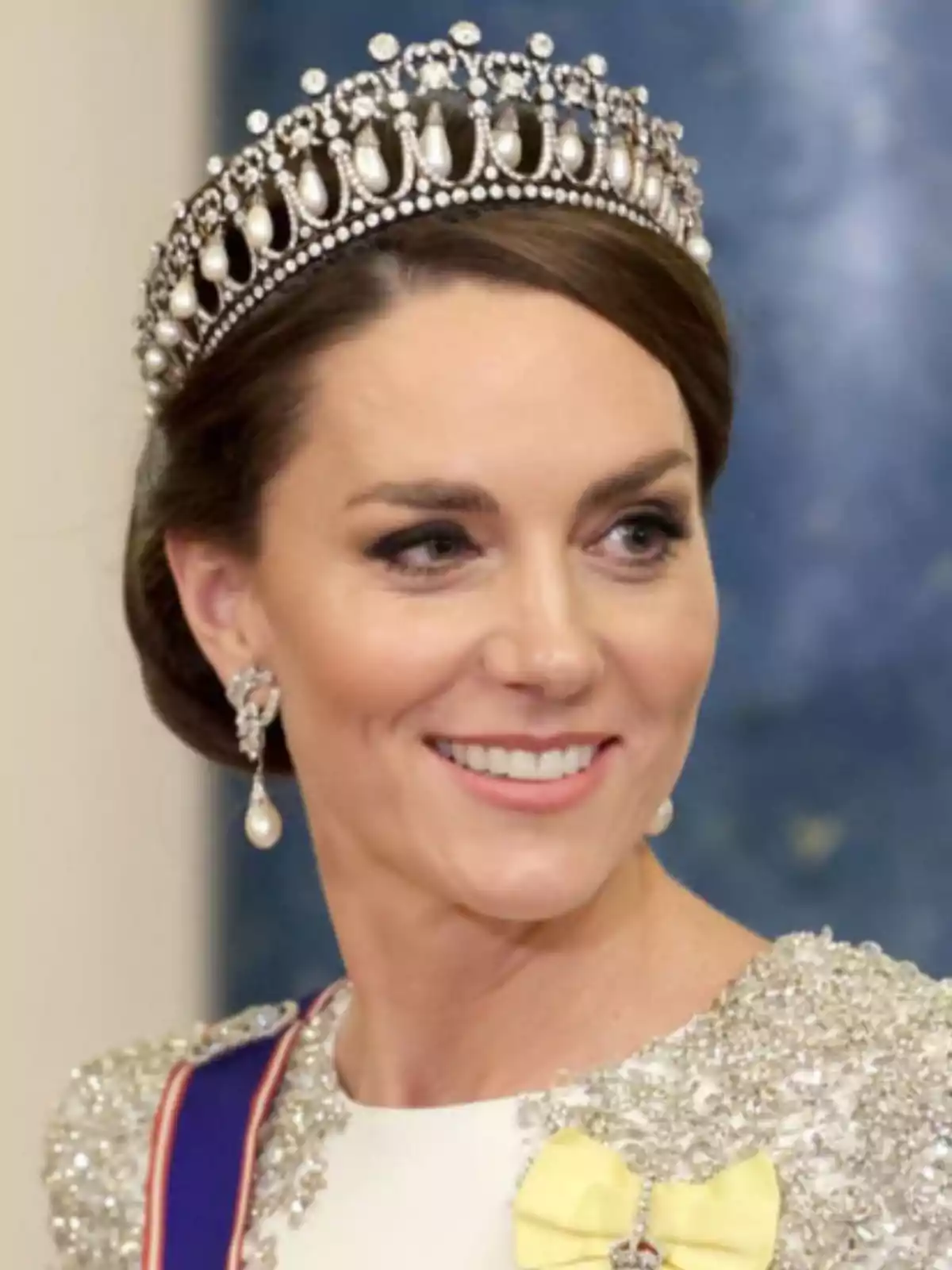 Smiling woman with a pearl and diamond tiara, elegant dress with sparkling details, and a yellow bow Smiling woman with a pearl and diamond tiara, elegant dress with sparkling details, and a yellow bow