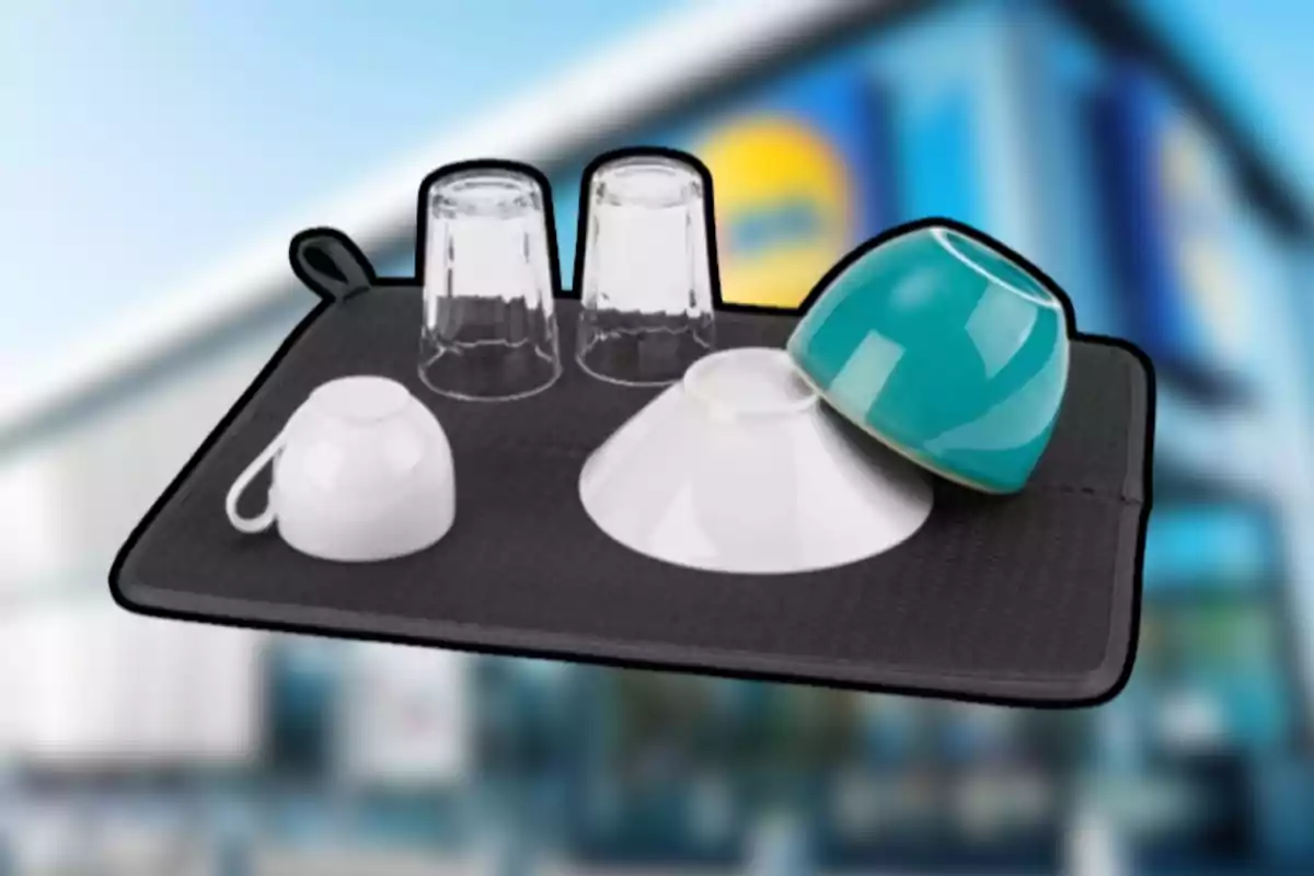 Tapete negro para secar platos con vasos y tazas sobre él frente a un fondo borroso de supermercado. Tapete negro para secar platos con vasos y tazas sobre él frente a un fondo borroso de supermercado.