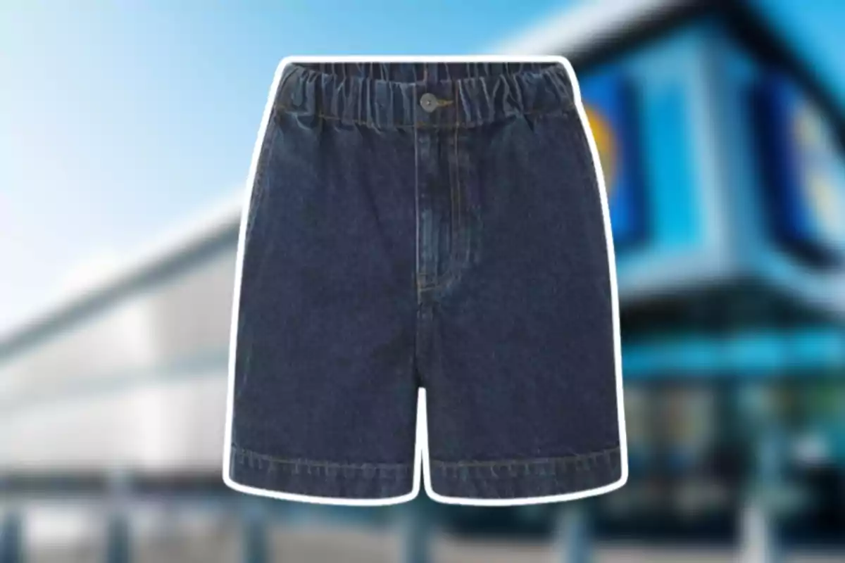 Shorts de mezclilla azul con resorte en la cintura y botón al frente sobre un fondo desenfocado de un edificio moderno Shorts de mezclilla azul con resorte en la cintura y botón al frente sobre un fondo desenfocado de un edificio moderno