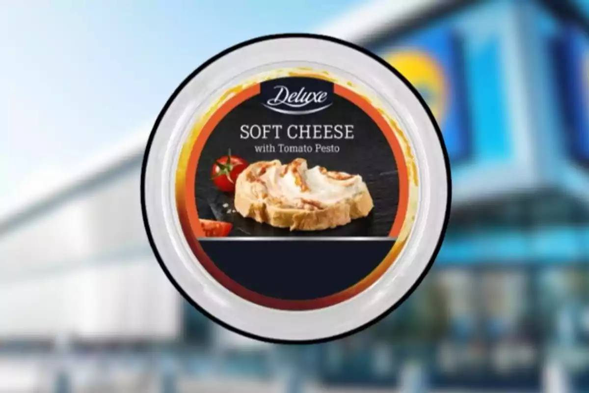 Envase de queso crema suave con pesto de tomate de la marca Deluxe sobre un fondo borroso de supermercado. Envase de queso crema suave con pesto de tomate de la marca Deluxe sobre un fondo borroso de supermercado.