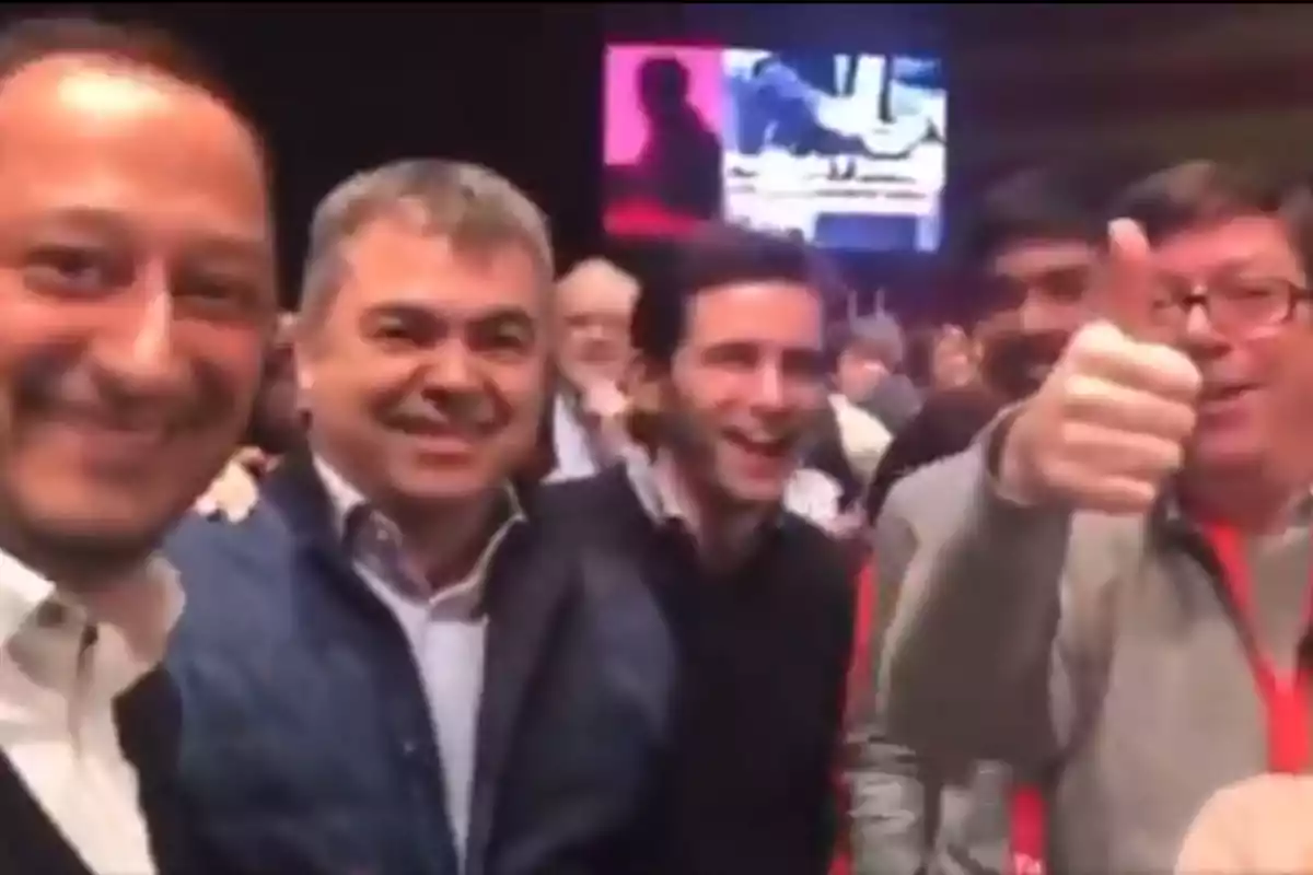 Grupo de hombres sonrientes posando para una foto en un evento, uno de ellos muestra el pulgar hacia arriba Grupo de hombres sonrientes posando para una foto en un evento, uno de ellos muestra el pulgar hacia arriba