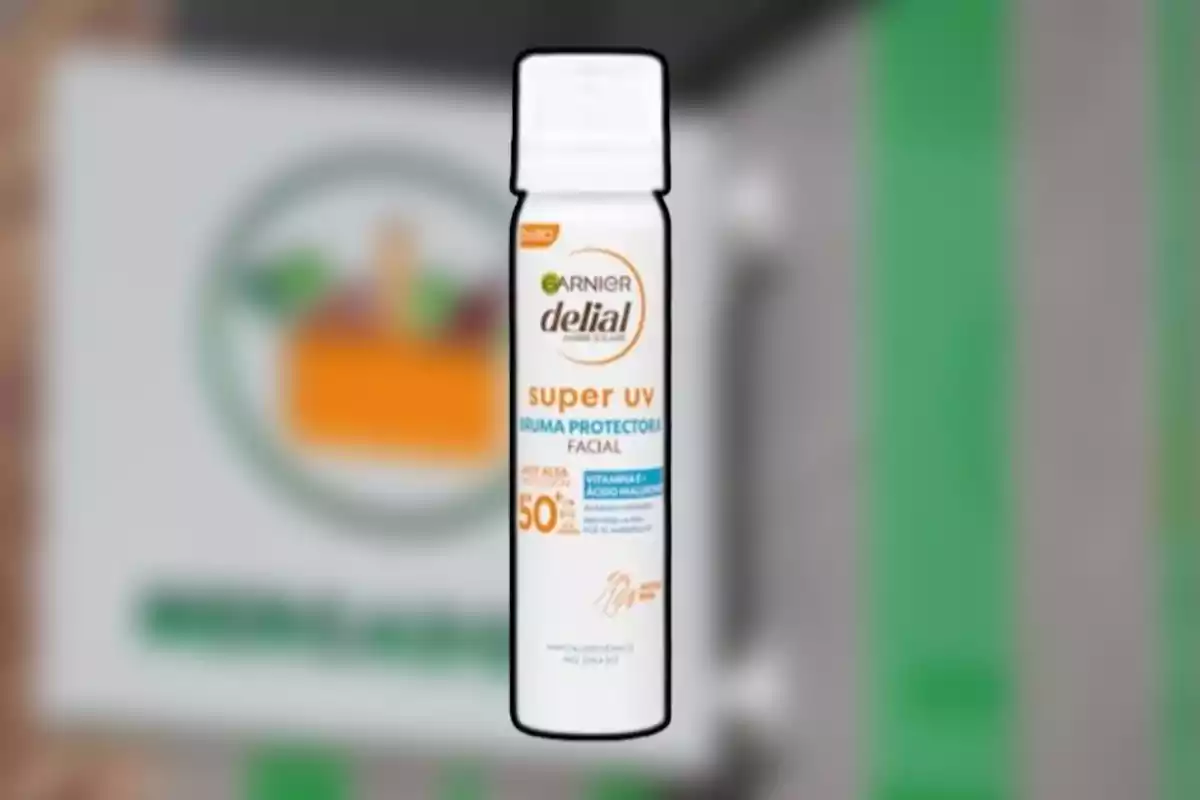 Envase de bruma protectora facial Garnier Delial Super UV con factor de protección solar 50 sostenido frente a un fondo desenfocado Envase de bruma protectora facial Garnier Delial Super UV con factor de protección solar 50 sostenido frente a un fondo desenfocado