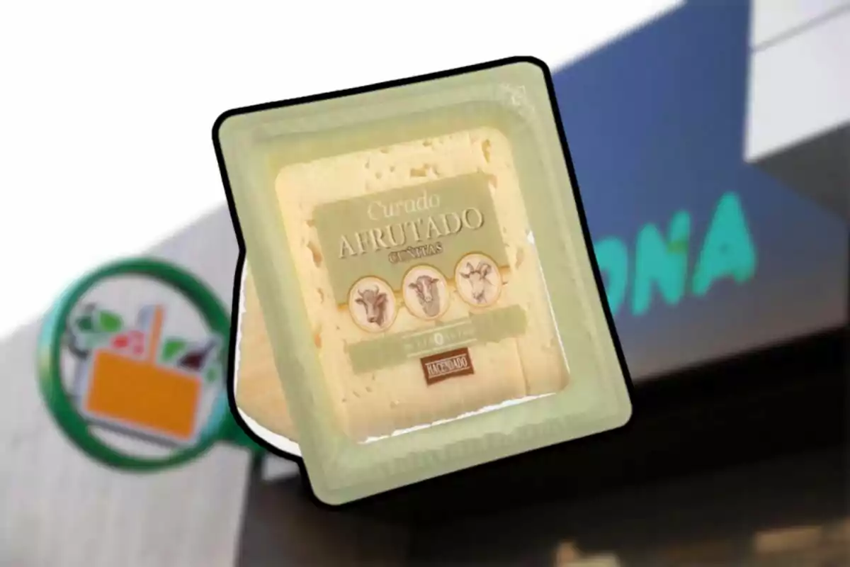 Queso curado afrutado envasado de la marca Hacendado frente a una tienda Mercadona desenfocada