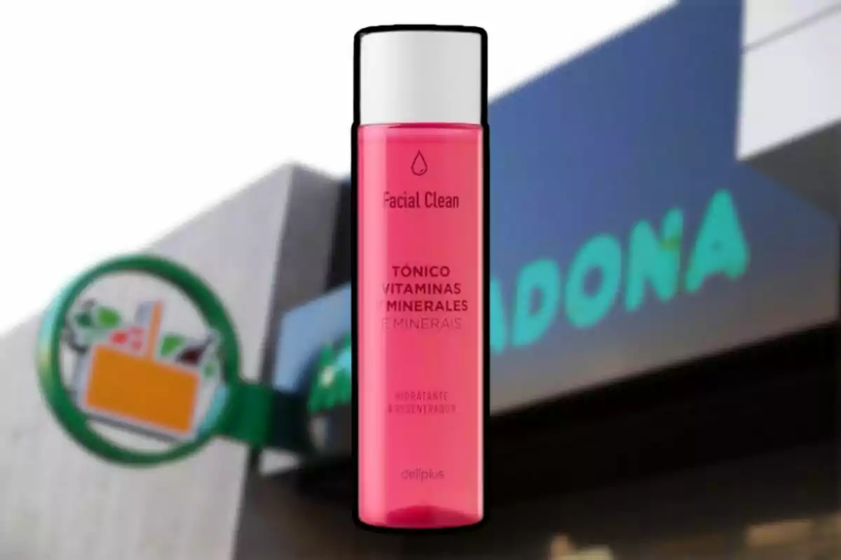 Botella de tónico facial Deliplus de color rosa frente a una tienda Mercadona desenfocada Botella de tónico facial Deliplus de color rosa frente a una tienda Mercadona desenfocada