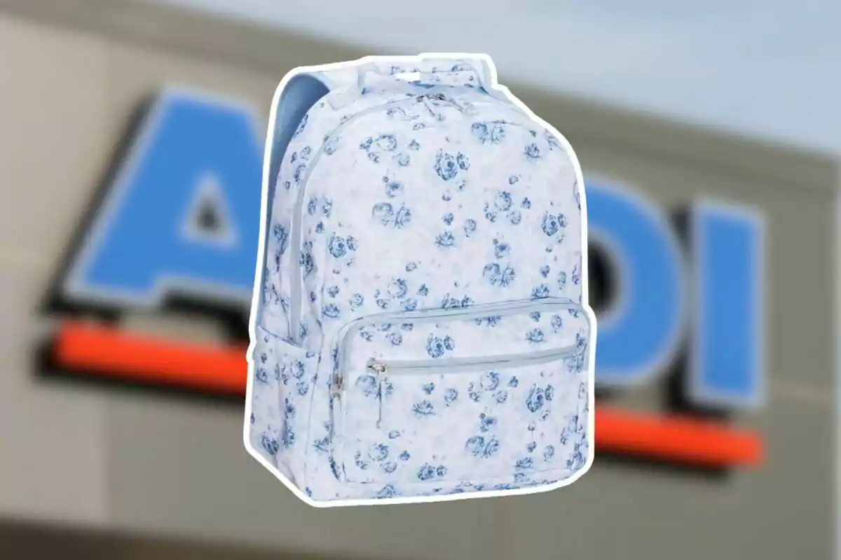 White backpack with blue flower print in front of a blurry store sign. White backpack with blue flower print in front of a blurry store sign.