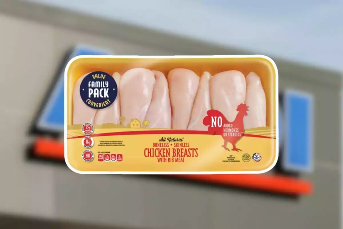 Tray of raw, boneless, skinless chicken breasts in family-size packaging with nutrition labels and a blurred grocery store background Tray of raw, boneless, skinless chicken breasts in family-size packaging with nutrition labels and a blurred grocery store background