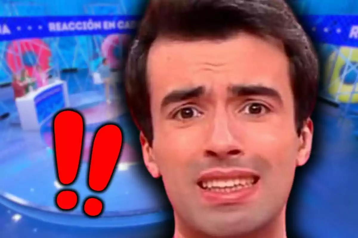 Primer plano de Bruno Vila con expresión de sorpresa o preocupación en un set de televisión con signos de exclamación rojos al lado de su rostro.