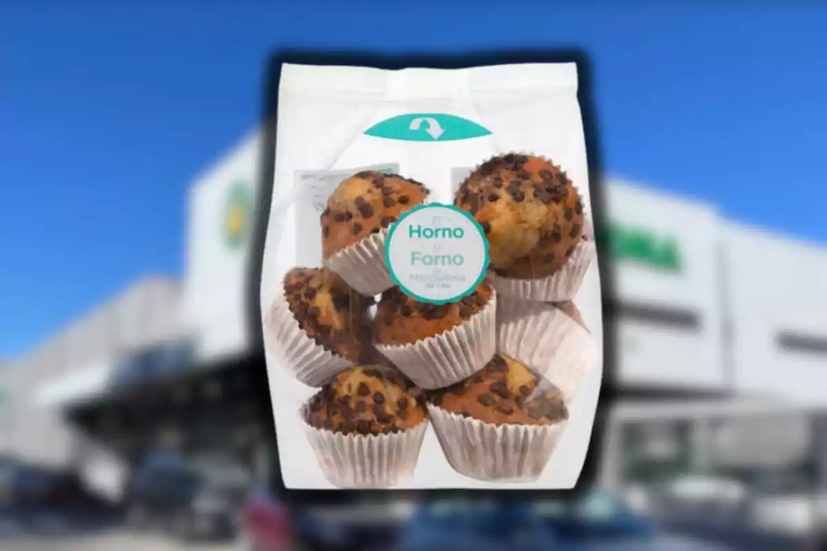 Bolsa de magdalenas con chispas de chocolate en empaque transparente frente a un supermercado desenfocado Bolsa de magdalenas con chispas de chocolate en empaque transparente frente a un supermercado desenfocado