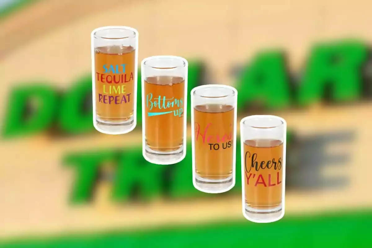 Four shot glasses with colorful phrases and amber drink in front of a blurred background with green letters. Four shot glasses with colorful phrases and amber drink in front of a blurred background with green letters.