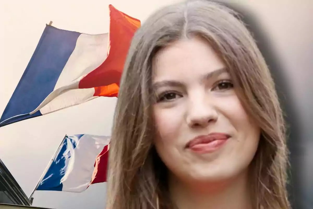 Primer plano de la infanta Sofía sonriente con banderas de Francia ondeando al fondo.