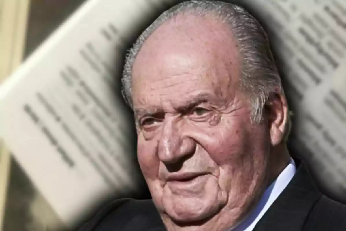Primer plano del rey Juan Carlos Icon fondo desenfocado de páginas de un libro.