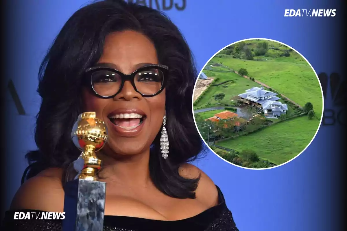 Mujer sonriente con gafas sostiene un trofeo dorado mientras al fondo se muestra una casa grande rodeada de áreas verdes