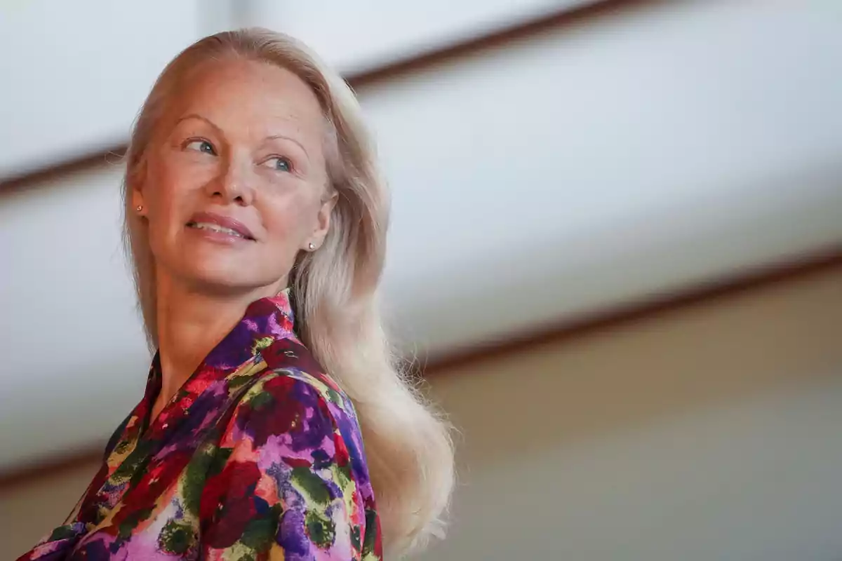 Pamela Anderson looking to the side and wearing a colorful floral print blouse Pamela Anderson looking to the side and wearing a colorful floral print blouse