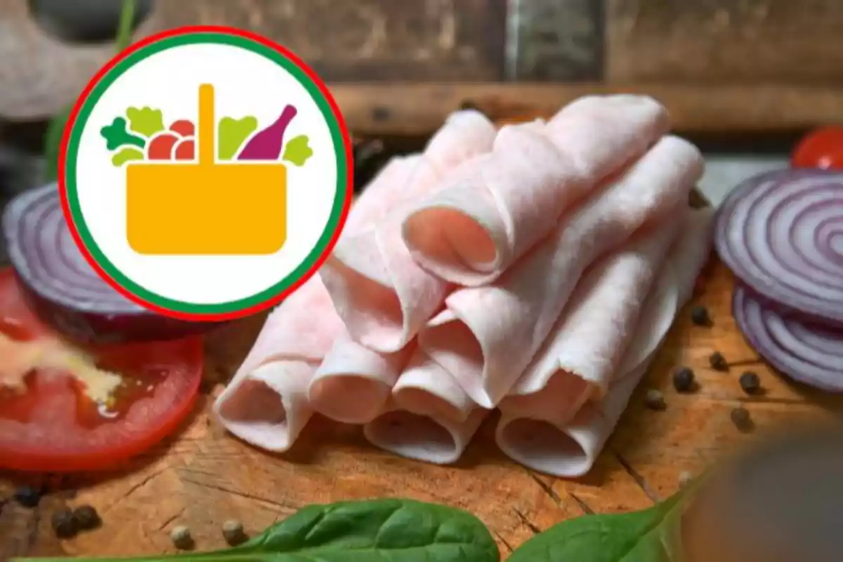 Rebanadas de jamón enrolladas sobre una tabla de madera junto a rodajas de tomate, cebolla morada y hojas verdes con un icono de canasta de supermercado en la esquina superior izquierda Rebanadas de jamón enrolladas sobre una tabla de madera junto a rodajas de tomate, cebolla morada y hojas verdes con un icono de canasta de supermercado en la esquina superior izquierda