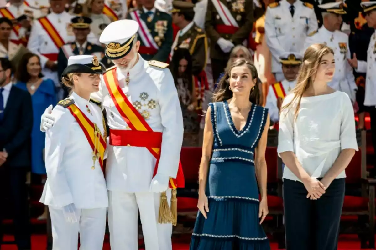 La princesa Leonor, Felipe VI, la reina Letizia y la infanta Sofía en primer plano durante un evento oficial con uniformes militares y vestimenta formal rodeados de más personas uniformadas en el fondo La princesa Leonor, Felipe VI, la reina Letizia y la infanta Sofía en primer plano durante un evento oficial con uniformes militares y vestimenta formal rodeados de más personas uniformadas en el fondo