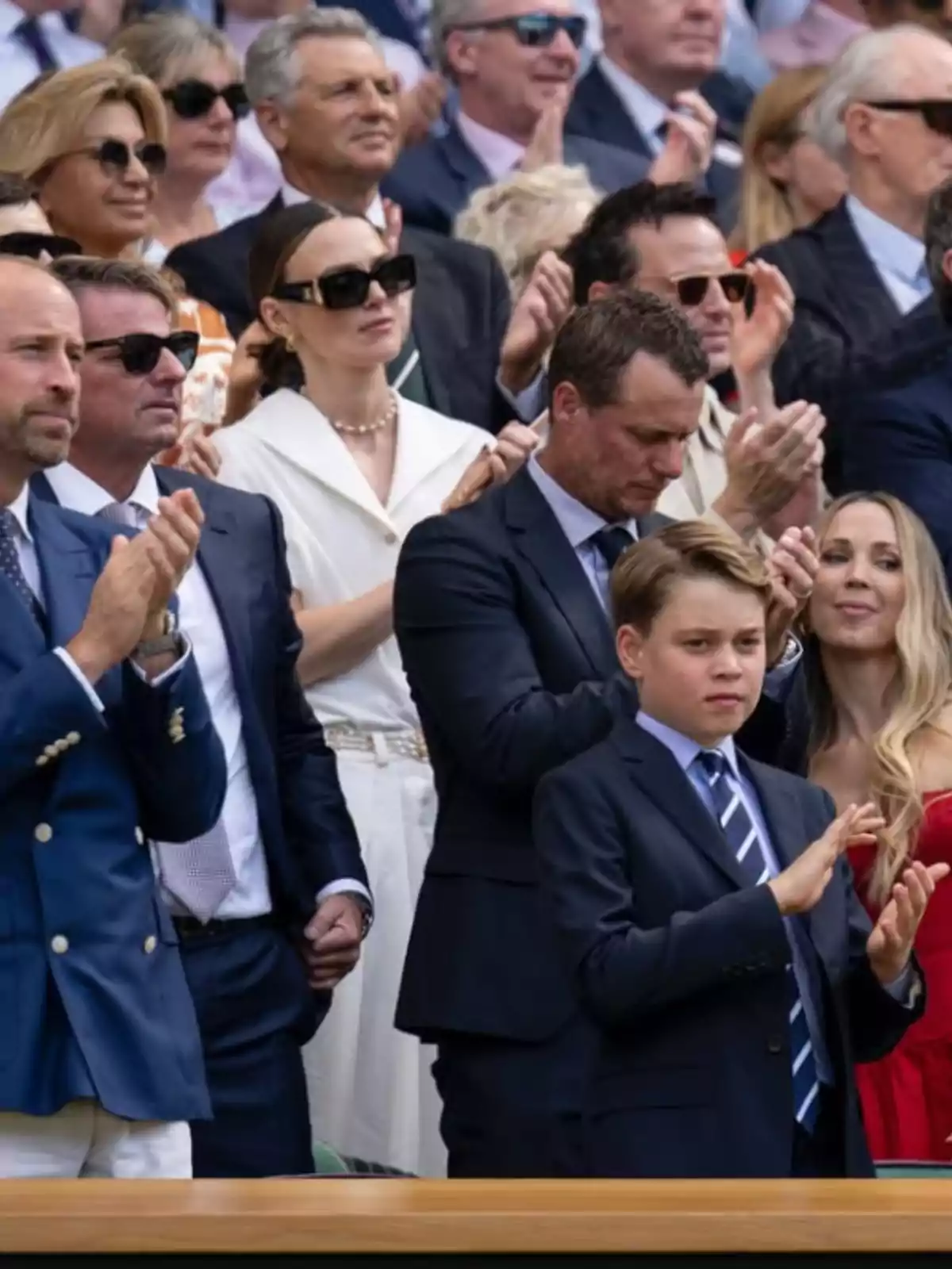 Group of elegantly dressed people applauding at an outdoor sporting event Group of elegantly dressed people applauding at an outdoor sporting event