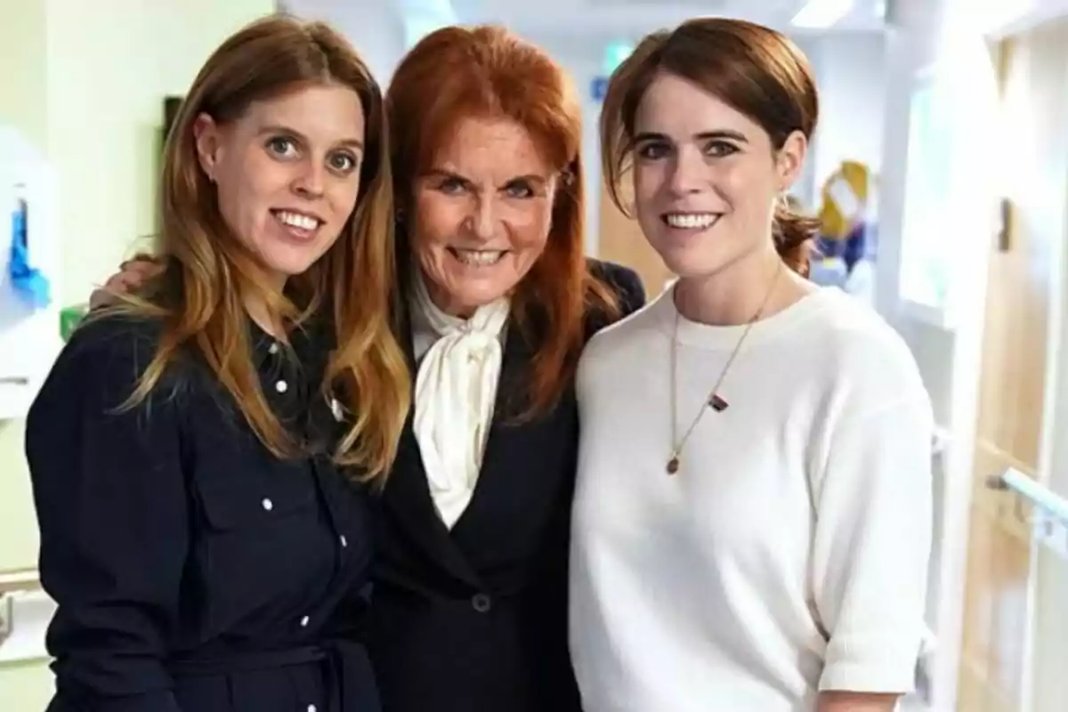 Three women smile and pose together in a brightly lit hallway. Three women smile and pose together in a brightly lit hallway.