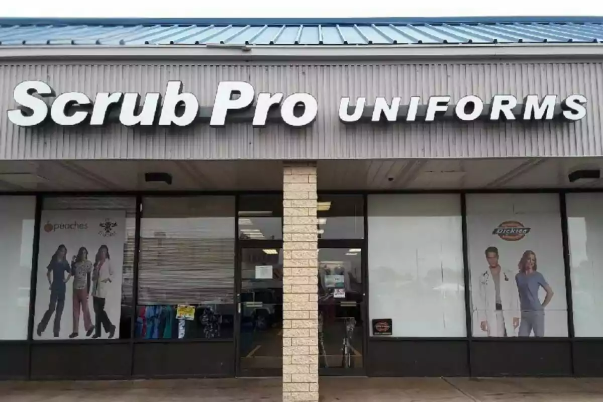 Storefront of a shop called Scrub Pro Uniforms with posters of models wearing medical uniforms in the windows. Storefront of a shop called Scrub Pro Uniforms with posters of models wearing medical uniforms in the windows.