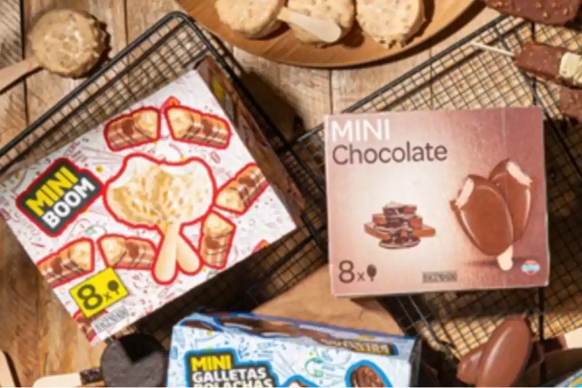 Cajas de helados mini de diferentes sabores sobre una mesa de madera junto a algunos helados fuera de su empaque Cajas de helados mini de diferentes sabores sobre una mesa de madera junto a algunos helados fuera de su empaque