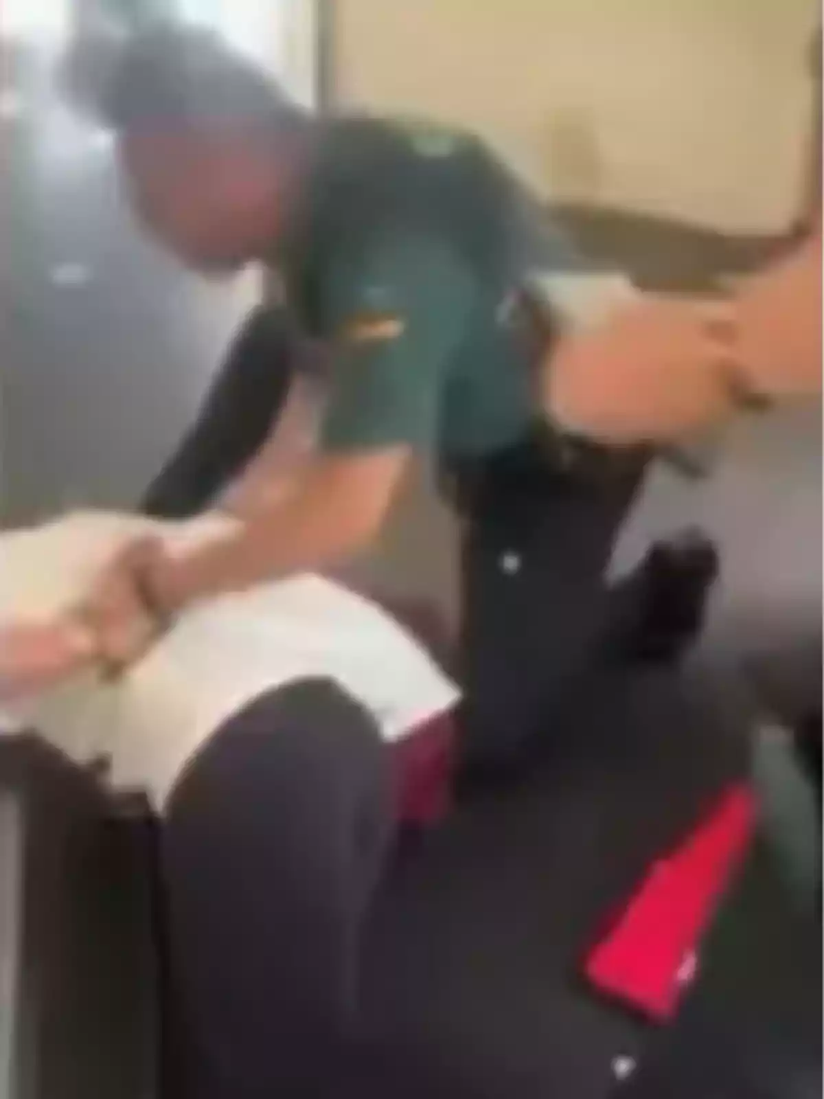 Un agente de policía reduce a una persona en el suelo dentro de un edificio Un agente de policía reduce a una persona en el suelo dentro de un edificio