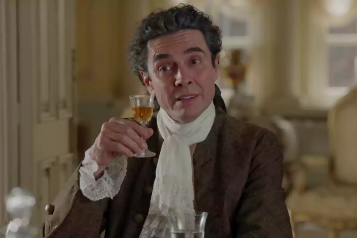 José Luis con vestimenta de época levantando una copa pequeña en un ambiente elegante. Captura de 'Valle Salvaje' José Luis con vestimenta de época levantando una copa pequeña en un ambiente elegante. Captura de 'Valle Salvaje'