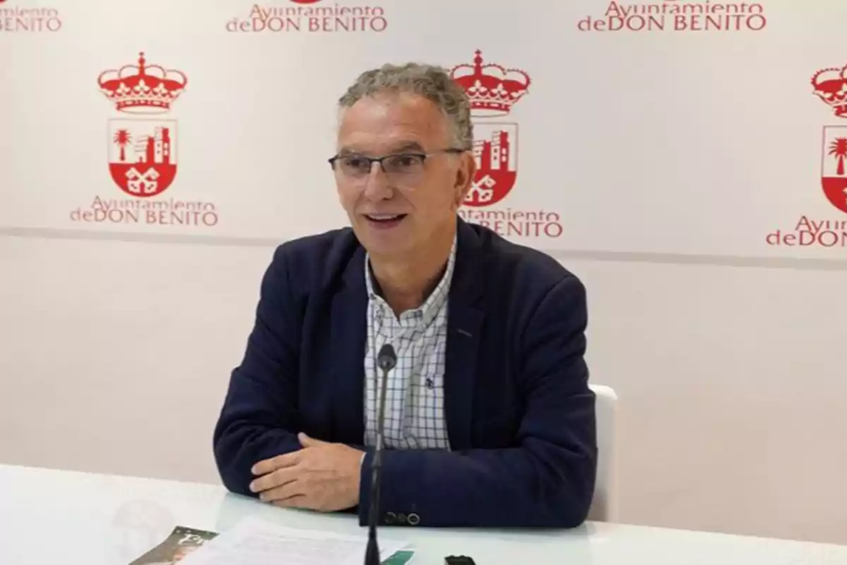 Hombre con gafas y chaqueta azul sentado en una mesa durante una rueda de prensa en el Ayuntamiento de Don Benito Hombre con gafas y chaqueta azul sentado en una mesa durante una rueda de prensa en el Ayuntamiento de Don Benito