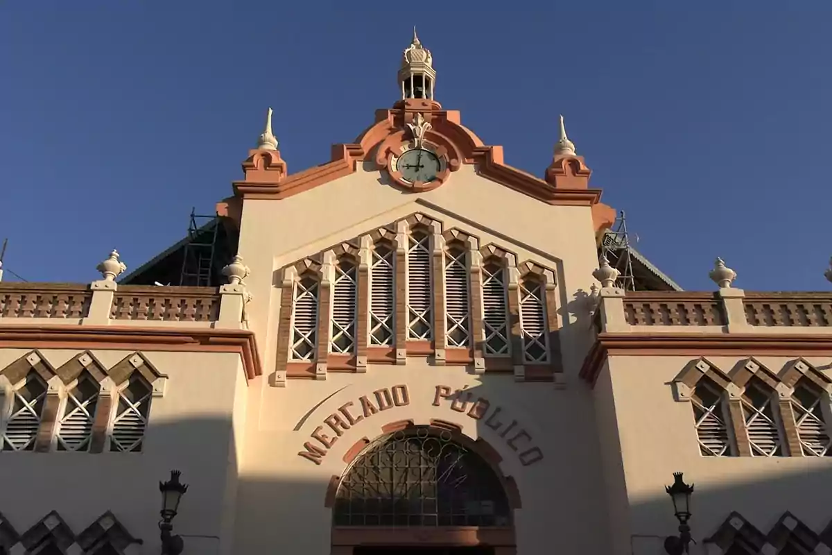 Fachada de un edificio antiguo con un reloj en la parte superior y la inscripción Mercado Público Fachada de un edificio antiguo con un reloj en la parte superior y la inscripción Mercado Público