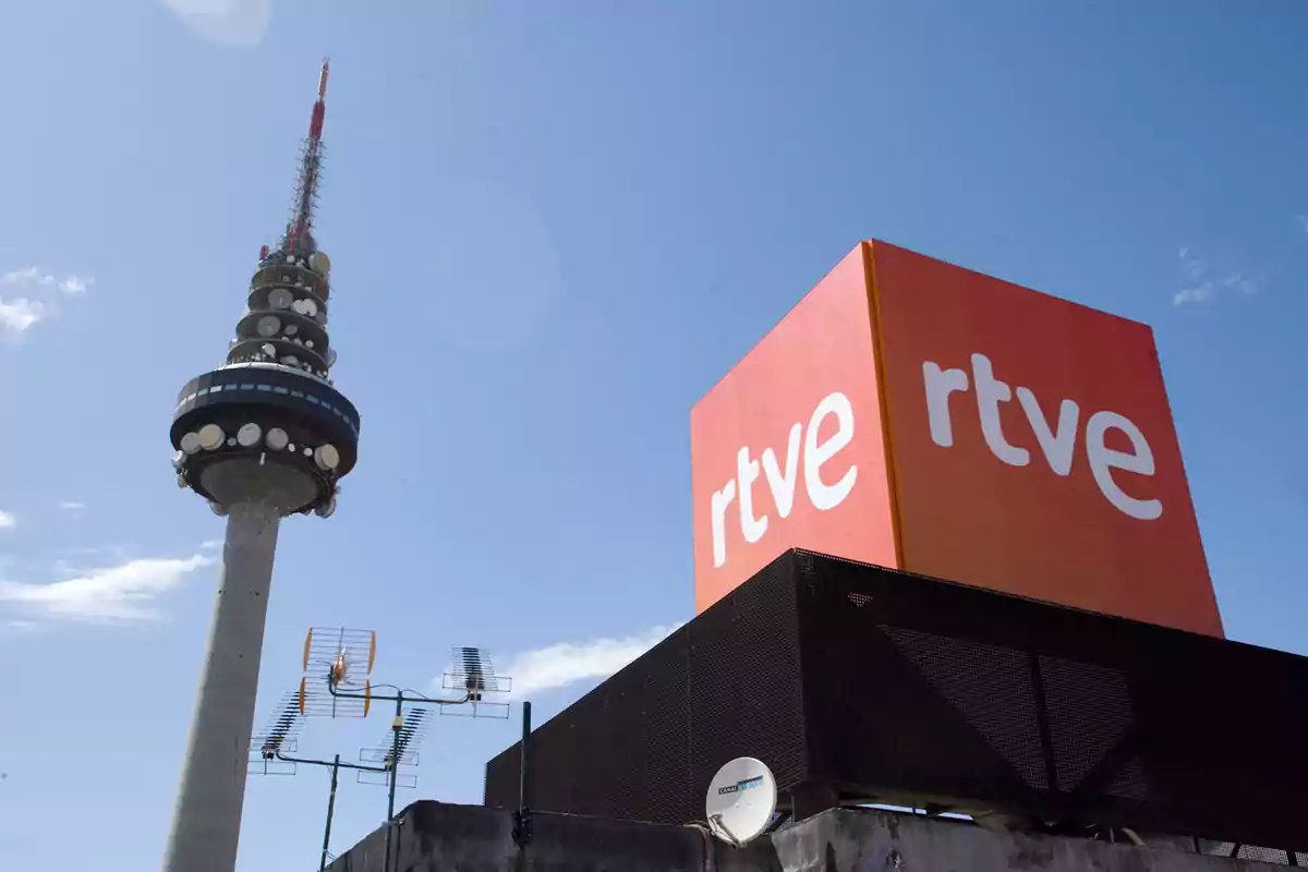 Edificio de RTVE junto a una torre de telecomunicaciones bajo un cielo despejado Edificio de RTVE junto a una torre de telecomunicaciones bajo un cielo despejado