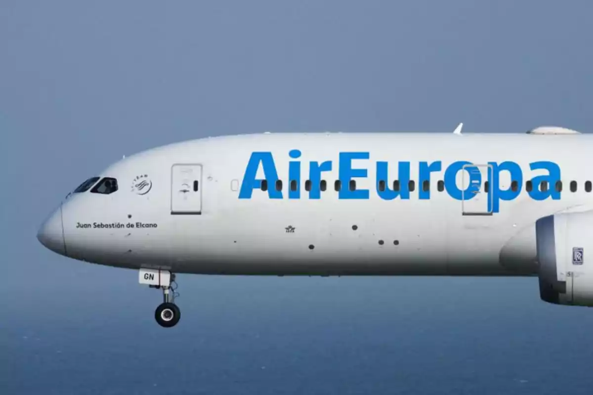 Avión de la aerolínea Air Europa volando sobre el mar con el nombre Juan Sebastián de Elcano visible en el fuselaje.