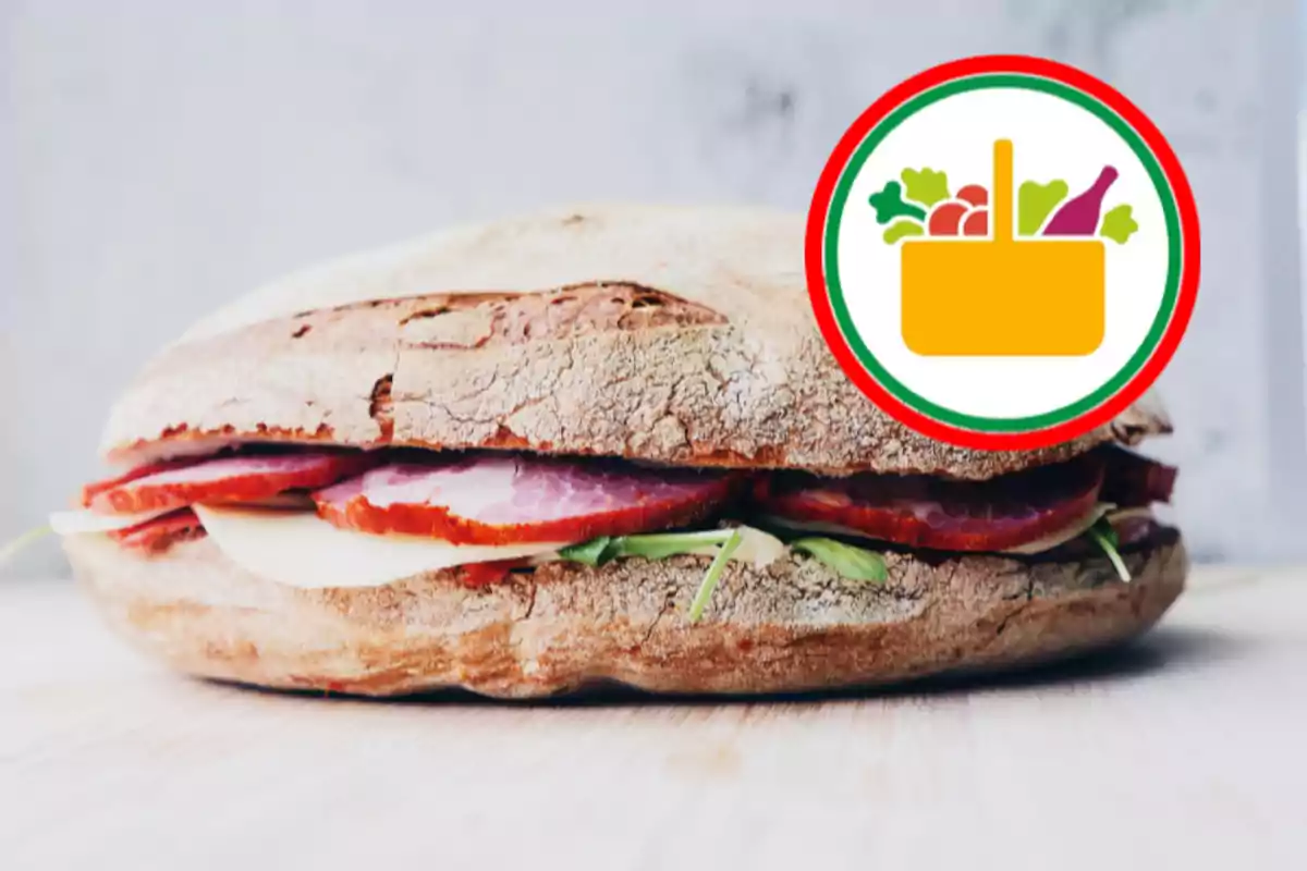 Un sándwich de pan rústico con jamón, queso y vegetales junto a un icono de canasta de supermercado Un sándwich de pan rústico con jamón, queso y vegetales junto a un icono de canasta de supermercado