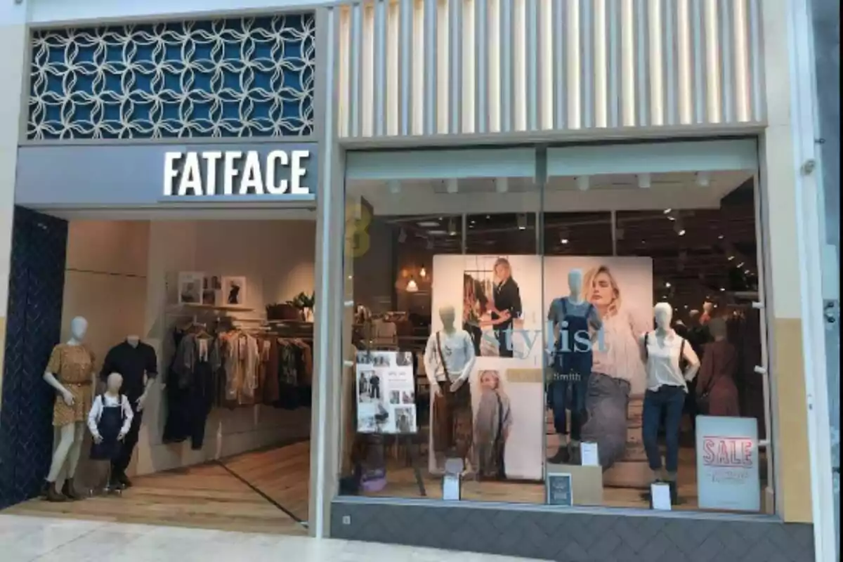 Storefront of a clothing shop called FatFace with mannequins in the window display and promotional signs in the showcase Storefront of a clothing shop called FatFace with mannequins in the window display and promotional signs in the showcase