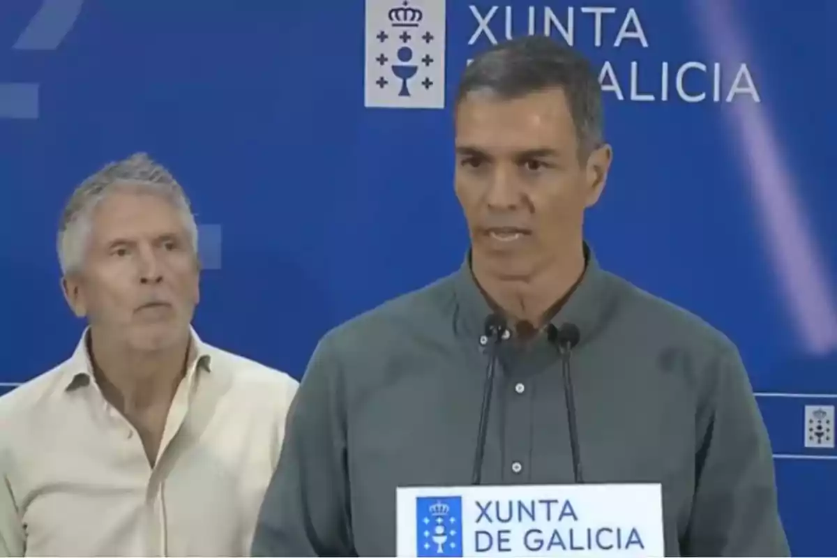 Dos hombres en una rueda de prensa frente a un fondo azul con el logo de la Xunta de Galicia