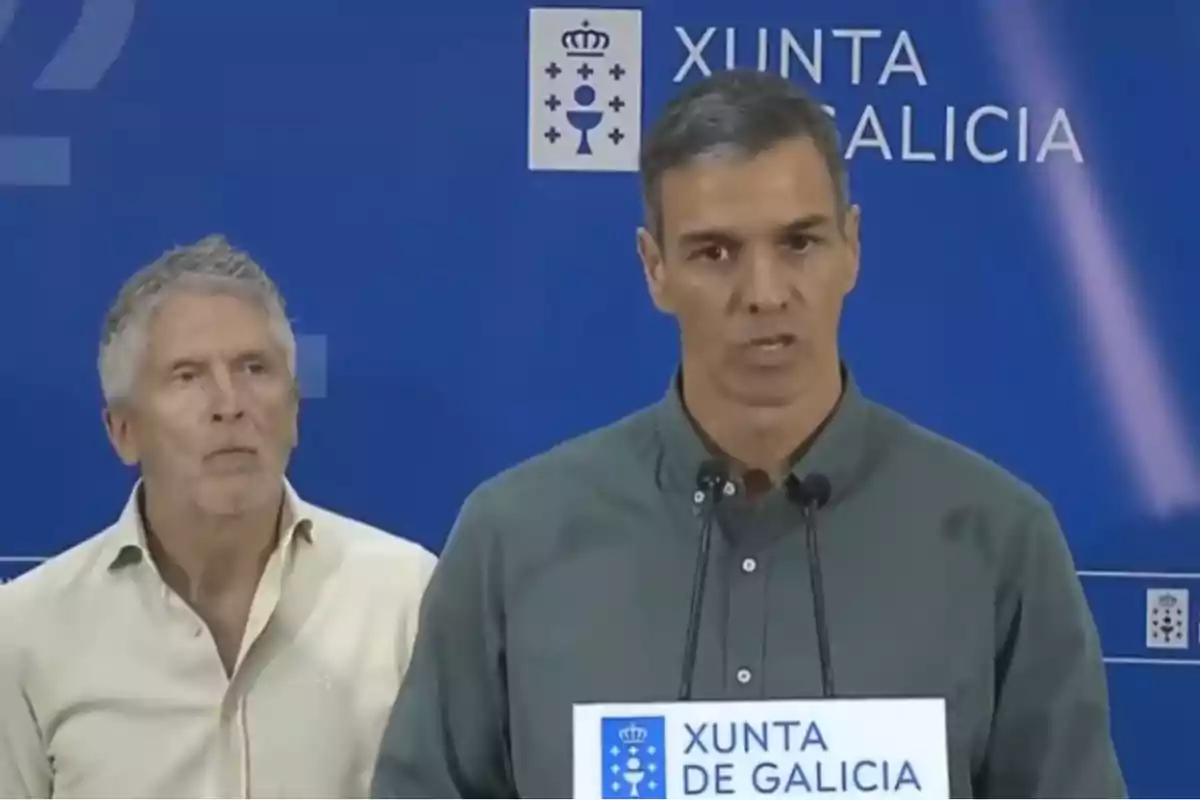 Dos hombres en una rueda de prensa frente a un fondo azul con el logo de la Xunta de Galicia Dos hombres en una rueda de prensa frente a un fondo azul con el logo de la Xunta de Galicia