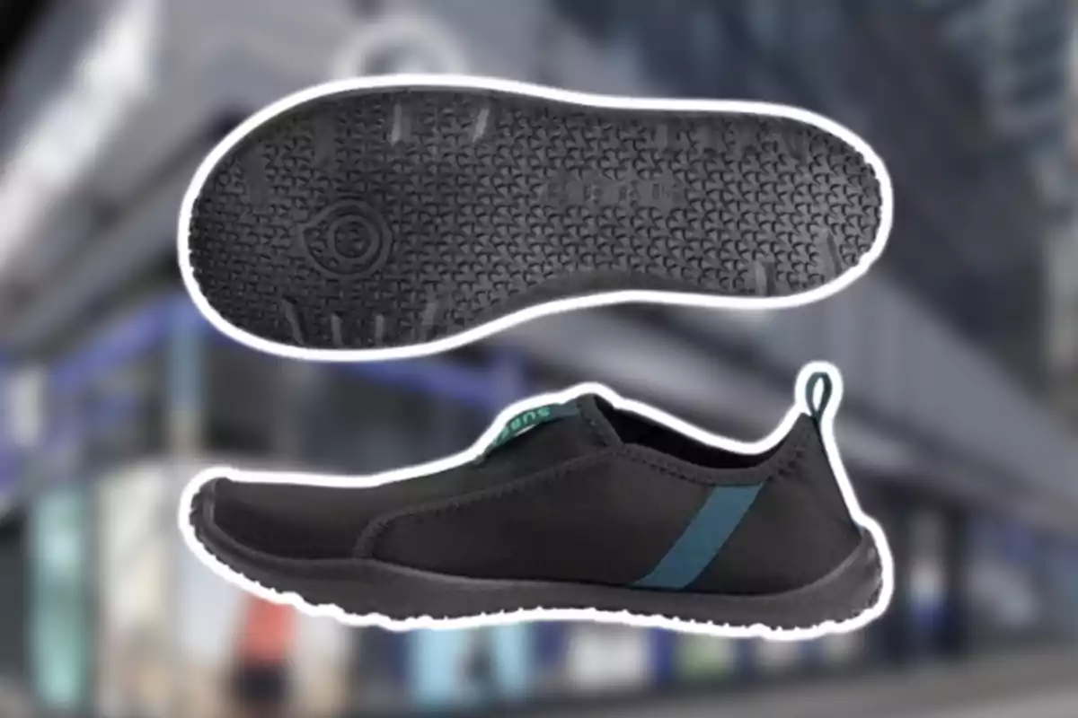 Zapato deportivo negro con suela de goma texturizada y detalle azul en el costado sobre un fondo urbano desenfocado Zapato deportivo negro con suela de goma texturizada y detalle azul en el costado sobre un fondo urbano desenfocado