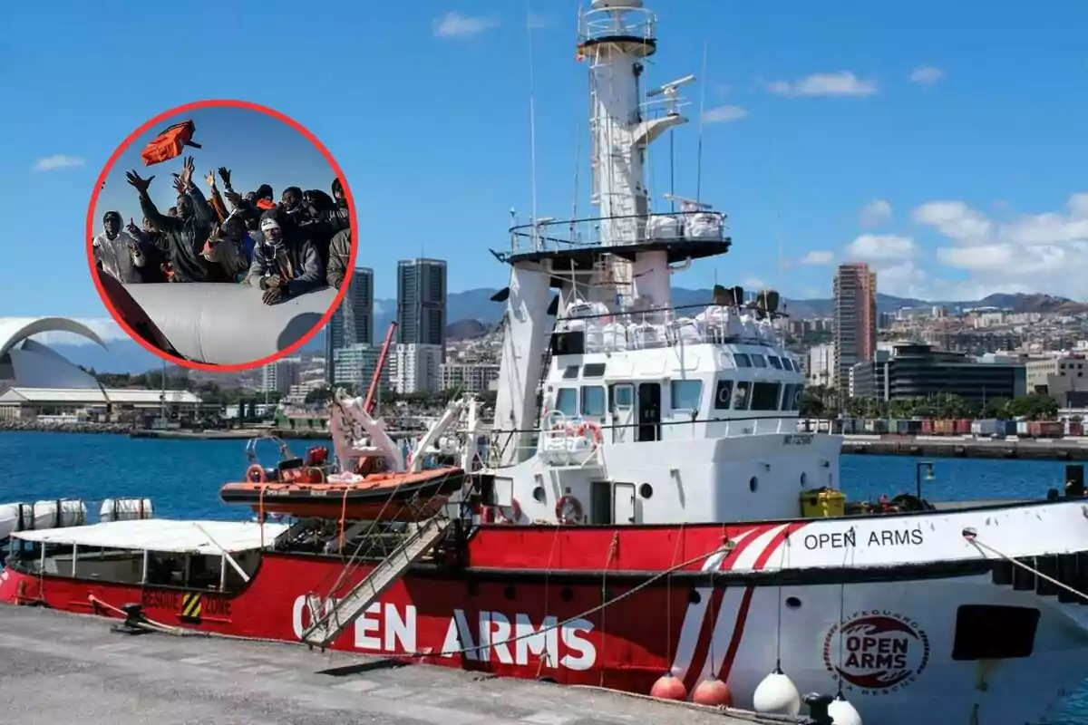 Barco de rescate Open Arms atracado en un puerto con una ciudad al fondo y un círculo que muestra a un grupo de personas migrantes saludando y levantando los brazos