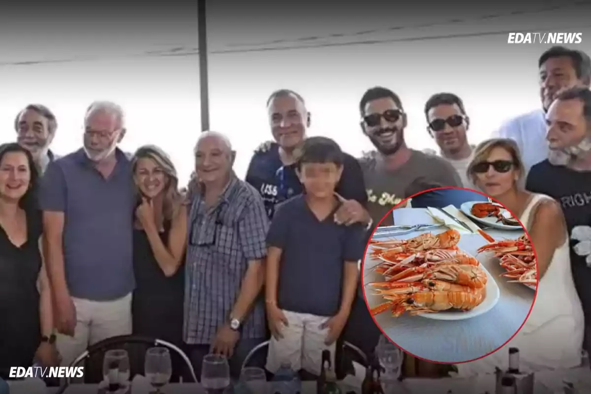Un grupo de personas sonríe posando para una foto en un restaurante mientras en la esquina inferior derecha se muestra un plato de mariscos