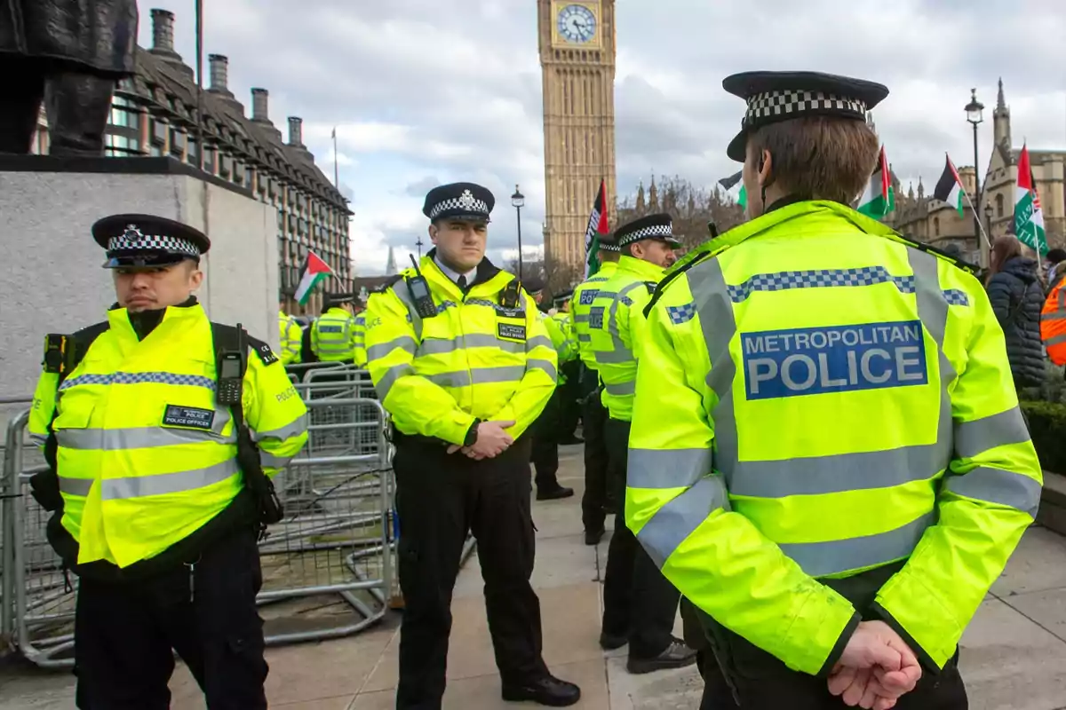 Varios policías con chalecos reflectantes de la policía metropolitana están de pie en una calle de Londres cerca del Big Ben durante una manifestación Varios policías con chalecos reflectantes de la policía metropolitana están de pie en una calle de Londres cerca del Big Ben durante una manifestación