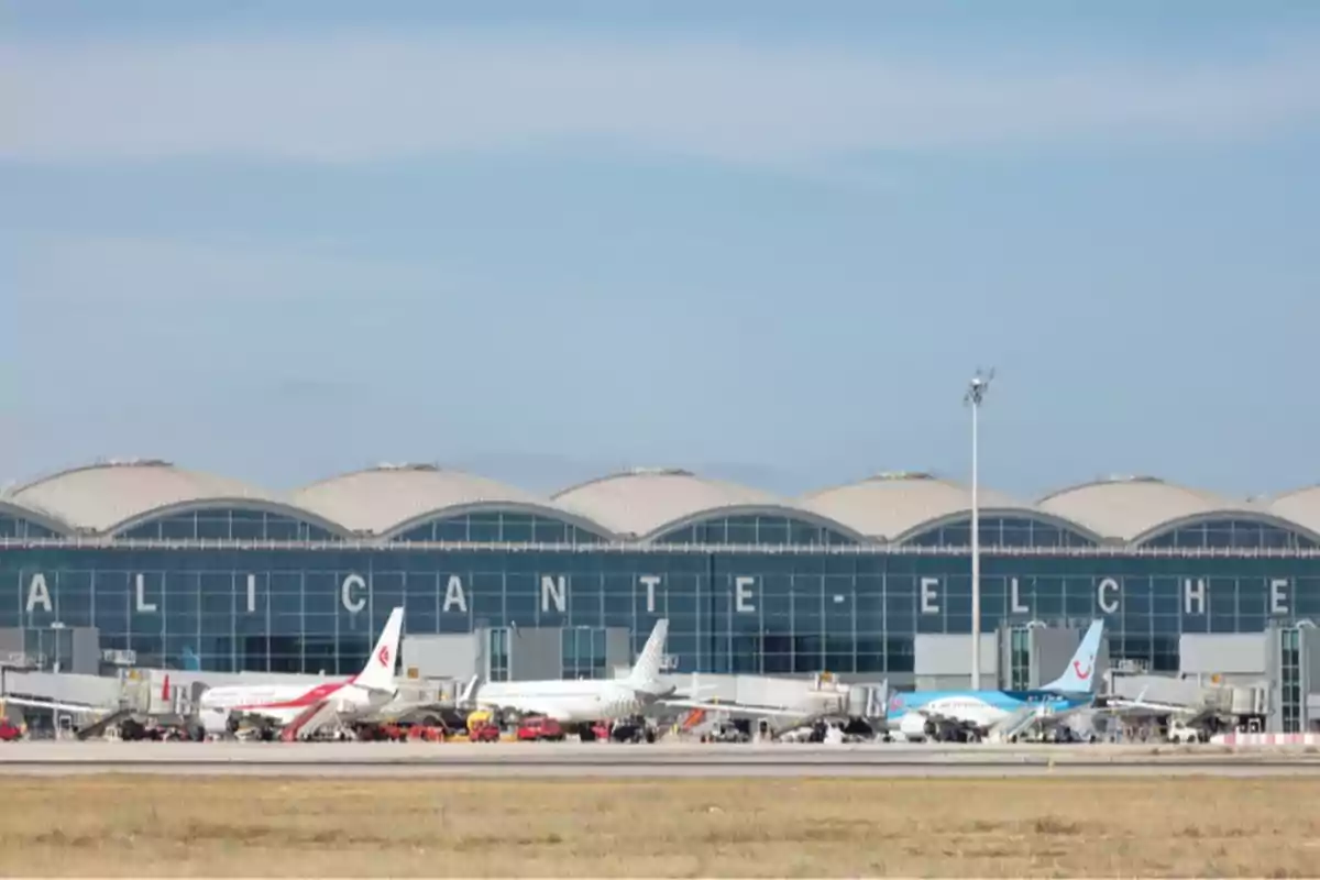 Fachada del aeropuerto de Alicante-Elche con varios aviones estacionados en la pista