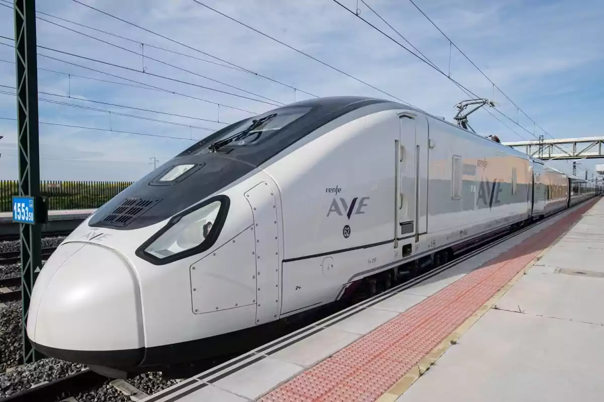Tren de alta velocidad AVE de Renfe detenido en una estación bajo un cielo despejado