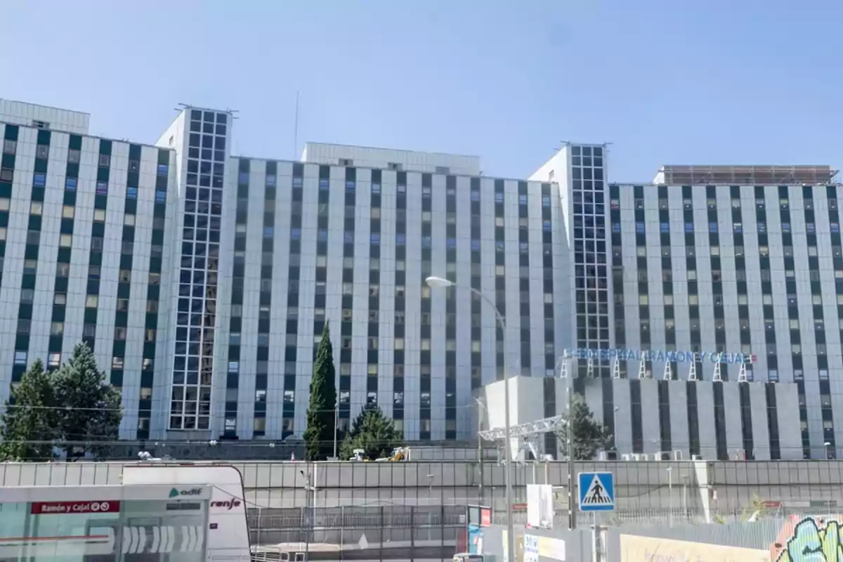 Fachada de un hospital grande con ventanas rectangulares y un letrero que dice Hospital Ramón y Cajal Fachada de un hospital grande con ventanas rectangulares y un letrero que dice Hospital Ramón y Cajal