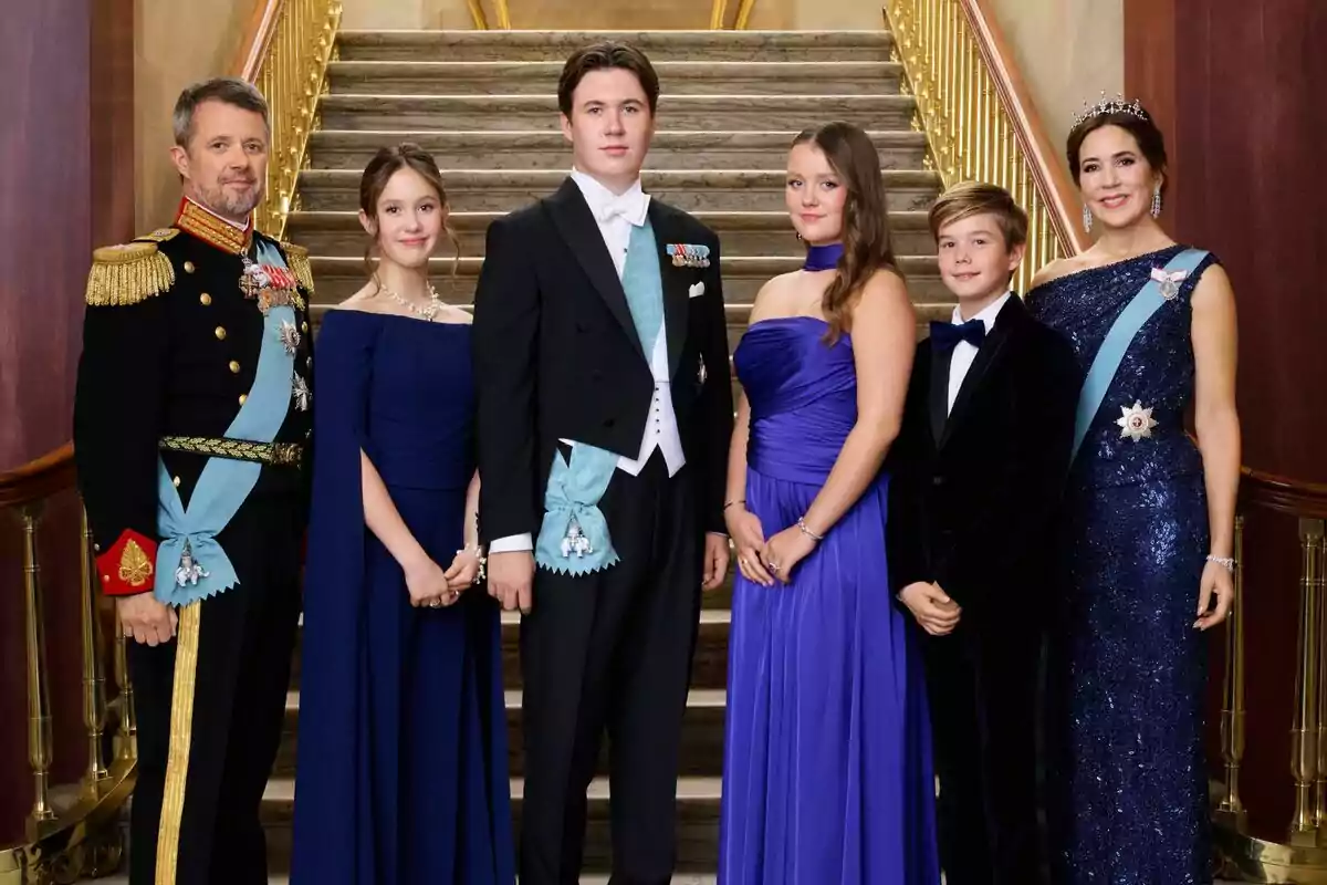 Federico, Josefina, Christian, Isabel, Vicente y Mary de Dinamarca elegantemente vestidas posan en una escalera de mármol con barandales dorados, algunas llevan bandas y medallas, y una mujer lleva una tiara Federico, Josefina, Christian, Isabel, Vicente y Mary de Dinamarca elegantemente vestidas posan en una escalera de mármol con barandales dorados, algunas llevan bandas y medallas, y una mujer lleva una tiara