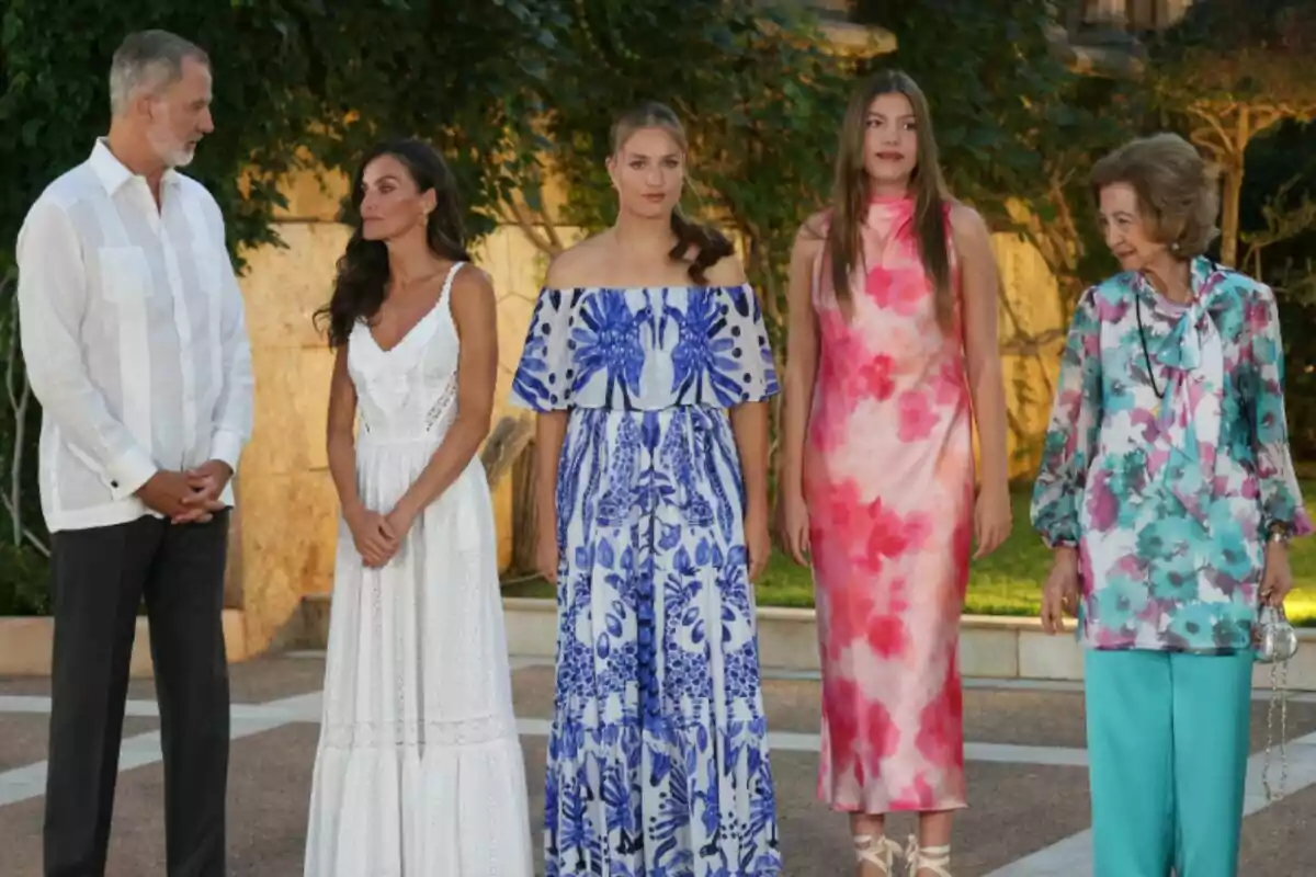 Felipe VI, la reina Letizia, la princesa Leonor, la infanta Sofía y la reina Sofía posan al aire libre con ropa elegante y colorida en un entorno ajardinado Felipe VI, la reina Letizia, la princesa Leonor, la infanta Sofía y la reina Sofía posan al aire libre con ropa elegante y colorida en un entorno ajardinado
