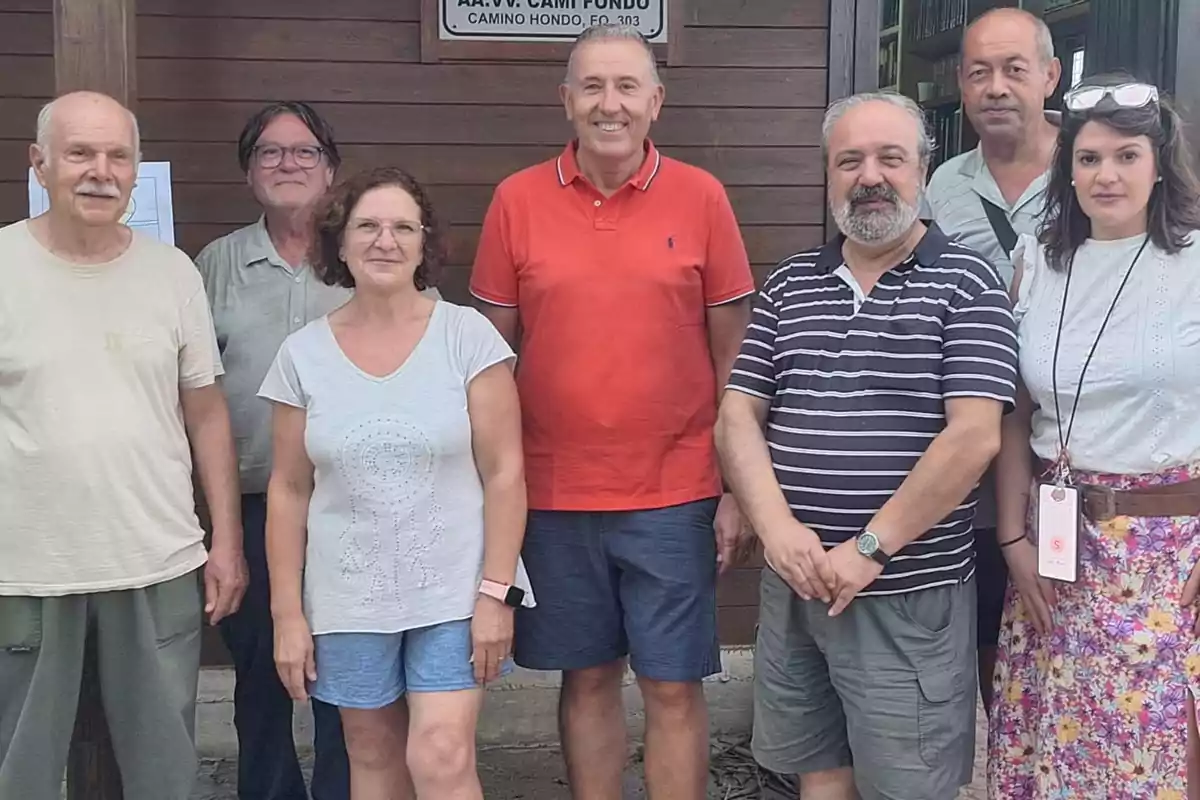 Un grupo de siete personas posa sonriente frente a una pared de madera, algunas de ellas llevan ropa casual y una mujer lleva gafas sobre la cabeza. Un grupo de siete personas posa sonriente frente a una pared de madera, algunas de ellas llevan ropa casual y una mujer lleva gafas sobre la cabeza.