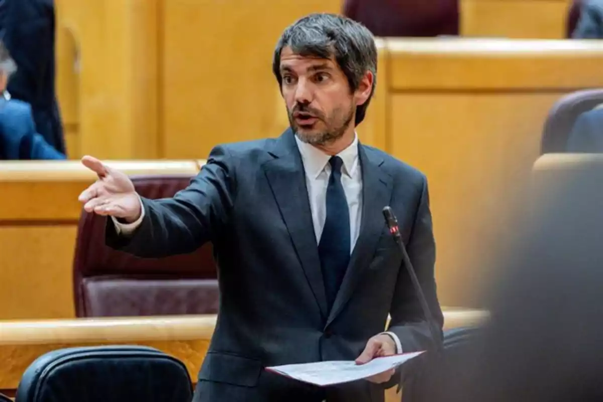 Hombre de traje hablando y gesticulando en un recinto parlamentario Hombre de traje hablando y gesticulando en un recinto parlamentario