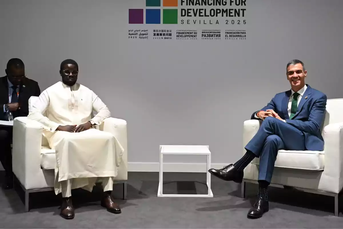 Dos hombres sentados en sillones blancos durante un evento de financiación para el desarrollo en Sevilla 2025