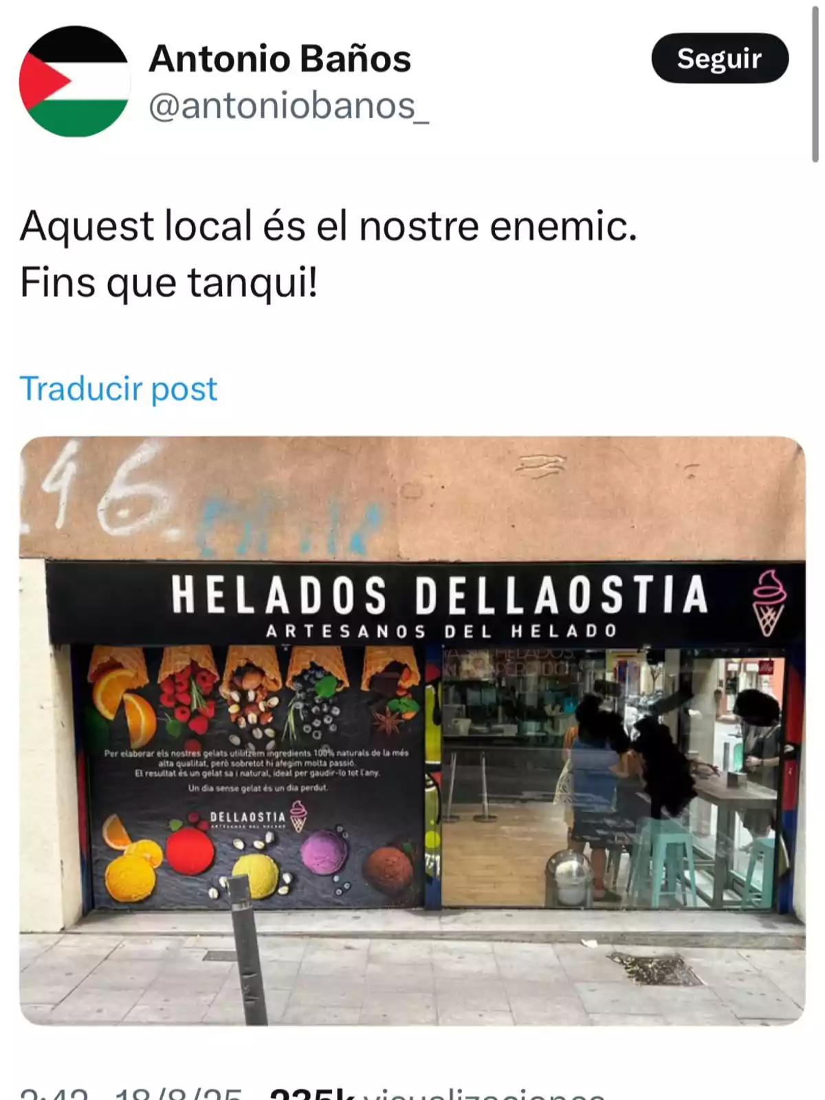 Heladería llamada Helados Dellaostia con fachada decorada con imágenes de frutas y helados, vista desde la calle, con personas sentadas en el interior Heladería llamada Helados Dellaostia con fachada decorada con imágenes de frutas y helados, vista desde la calle, con personas sentadas en el interior
